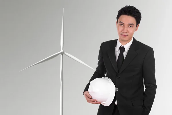 Інженер тримає шолом з фоном вітрової турбіни — стокове фото