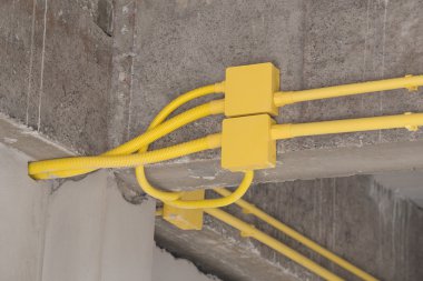 Elektrik kutuları ve kabloları concre üzerinde gömülü sarı Pvc boru