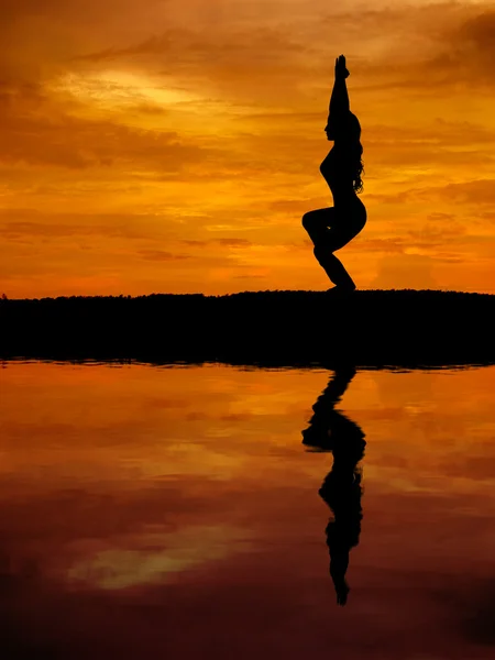 Silhouette of a beautiful Yoga woman with water reflection — Stock Photo, Image