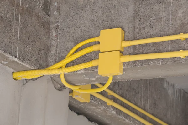 Yellow PVC pipes for electrical boxes and wires buried on concre — Stock Photo, Image