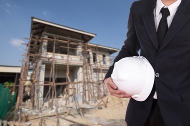 ev inşaat arka plan ile kask tutan mühendisi