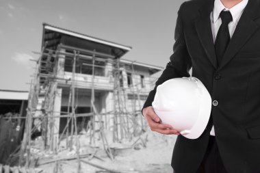 ev inşaat arka plan ile kask tutan mühendisi