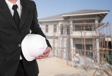 ev inşaat arka plan ile kask tutan mühendisi