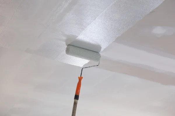 Покраска гипсового потолка роликом — стоковое фото