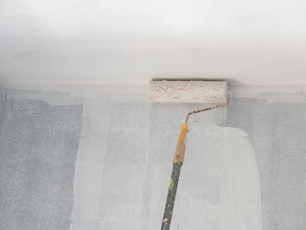 Покраска стены и потолка роликом — стоковое фото