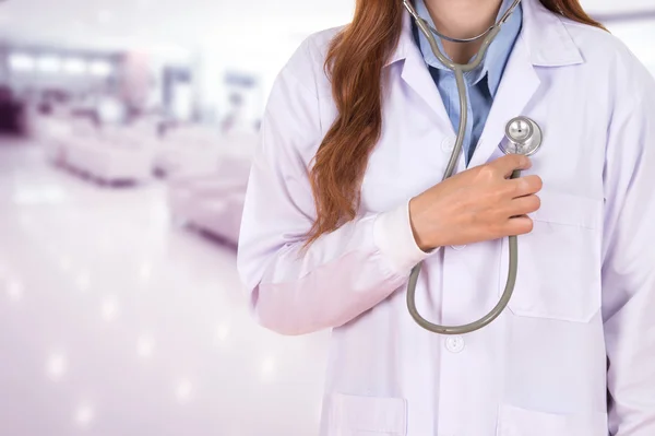 Female doctor listening his heart with stethoscope in hospital — Stock Photo, Image