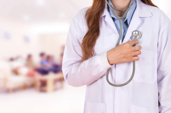 Female doctor listening his heart with stethoscope in hospital — Stock Photo, Image