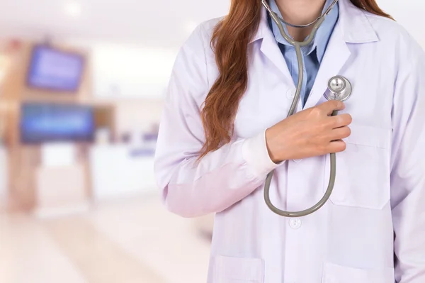 Женщина-врач слушает его сердце стетоскопом в больнице — стоковое фото