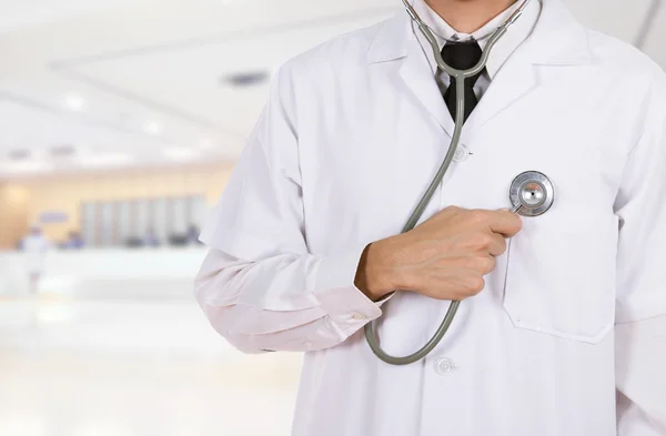 Doctor listening his heart with stethoscope in hospital — Stock Photo, Image