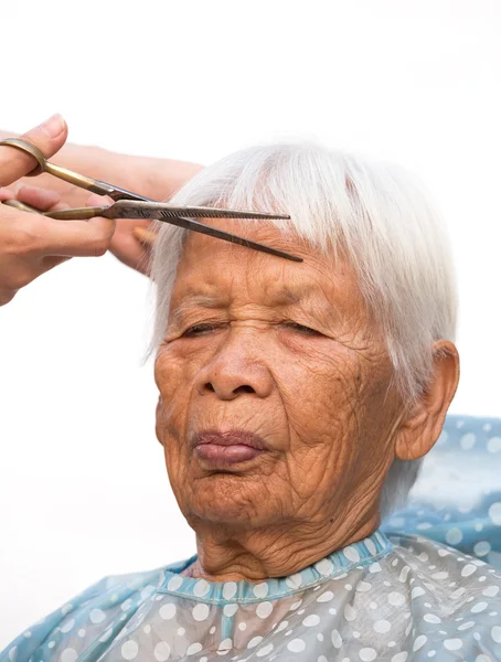 Cutting senior woman's gray hair — Stock Photo, Image