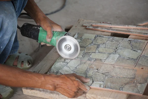 Stavební dělník řezání dlaždic pomocí úhlové brusky — Stock fotografie