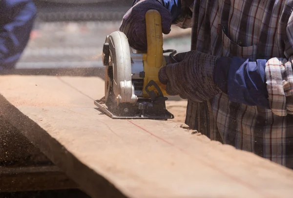 Carpenter use electric saw to sawing wood — Stock Photo, Image