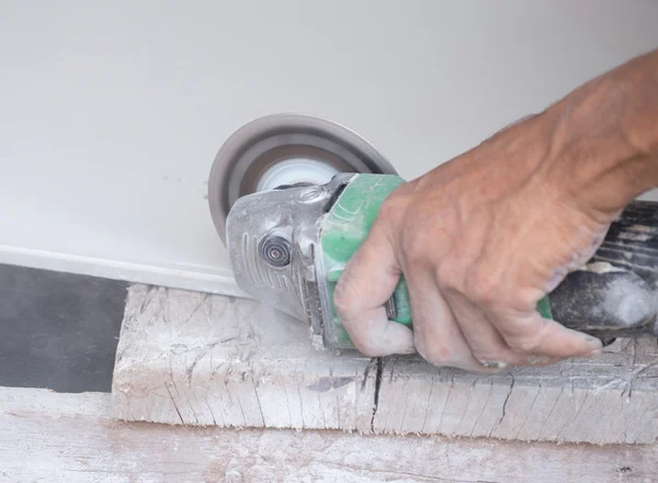 Worker cutting a tile using an angle grinder — Stock Photo, Image