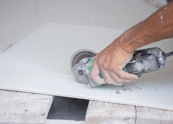 Worker cutting a tile using an angle grinder — Stock Photo, Image