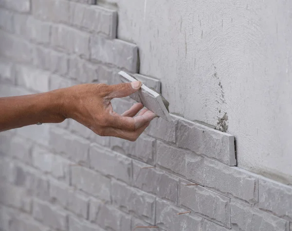 Travailleur installer carrelage mur en pierre avec du ciment pour la maison — Photo