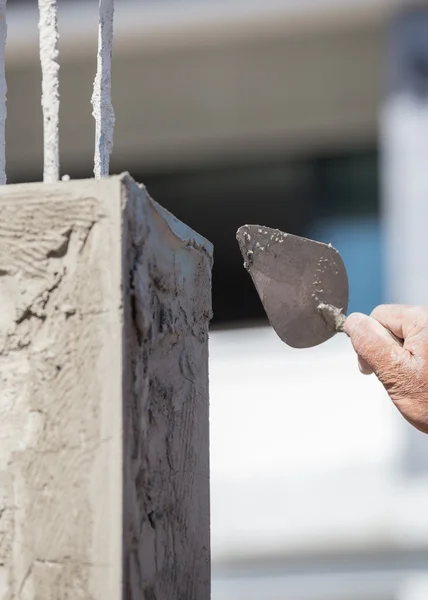 Arbeiter verwenden Kelle, die die Stangen verputzt — Stockfoto