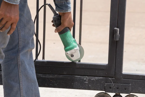 Worker using an angle grinder to grinding door frames — Stock Photo, Image