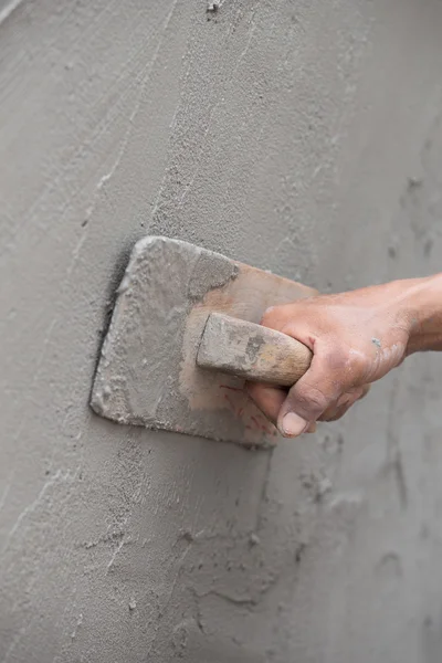 Arbejder bruger murske pudsning beton på væggen - Stock-foto