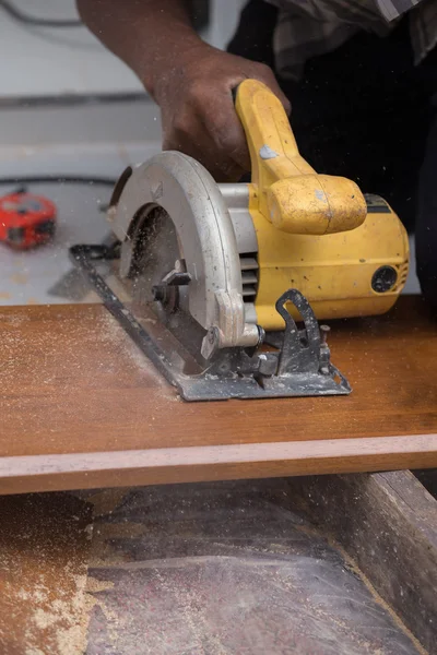 Carpintero uso de sierra eléctrica para aserrar madera — Foto de Stock