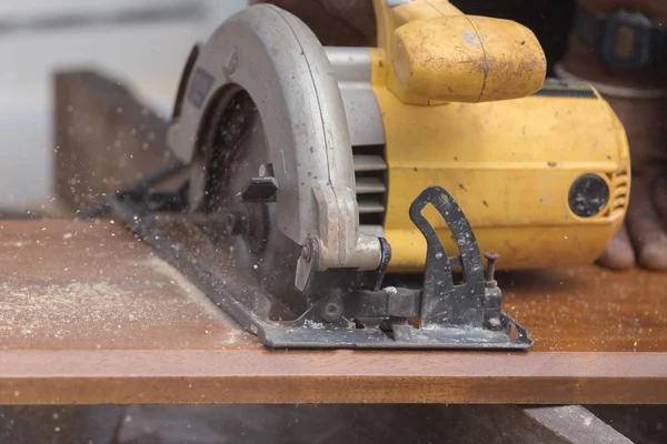Плотник использовать электропилу для распиловки древесины — стоковое фото