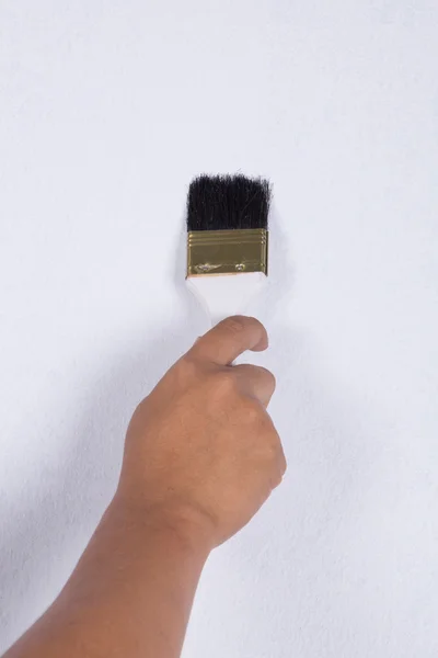 Mano con pintura de pincel en la pared — Foto de Stock