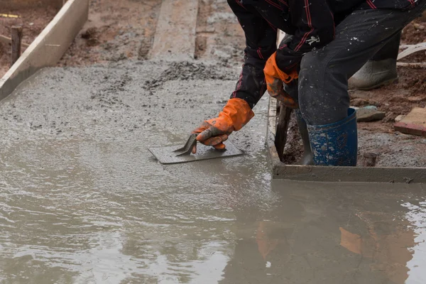 Tangan pekerja menggunakan plastering sekop flo beton yang baru dituangkan — Stok Foto