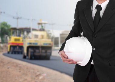 kask ile asfalt yol yazılımlar altında tutan takım elbiseli mühendisi