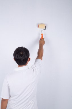 ressam adam duvar boya silindiri ile iş yerinde