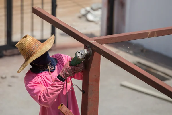 Travailleur utilisant la meuleuse pour meuler le métal — Photo