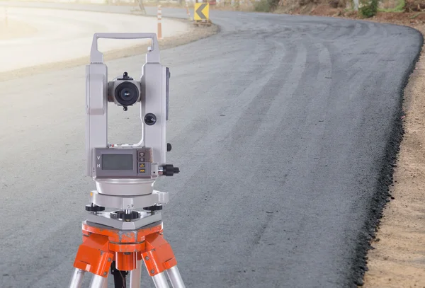 Survey equipment theodolite on a tripod.  with road under constr — Stock Photo, Image