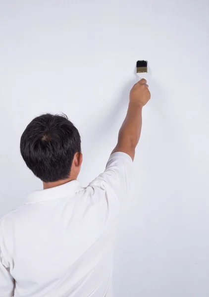 Schilder man aan het werk met een borstel schilderij aan de muur — Stockfoto