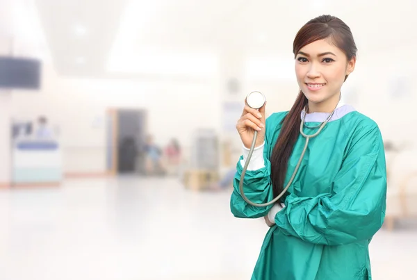Médico feminino vestindo um esfoliante verde e estetoscópio no hospital — Fotografia de Stock