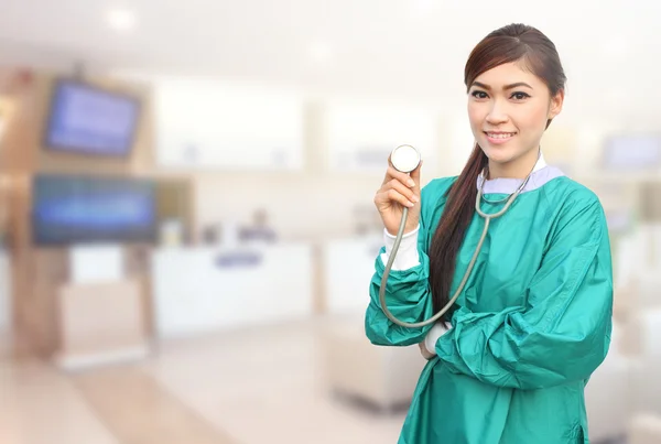 Kvinna läkare bär en grön scrubs och stetoskop på sjukhus — Stockfoto