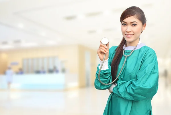 Žena doktor nosí co zelené křoviny a stetoskop v nemocnici — Stock fotografie