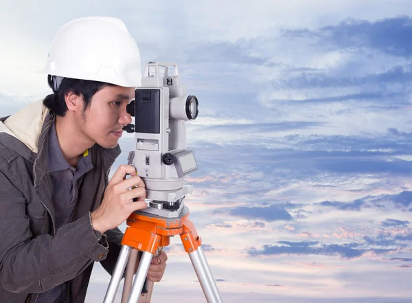 Anket ekipman teodolit ile günbatımında çalışan mühendis
