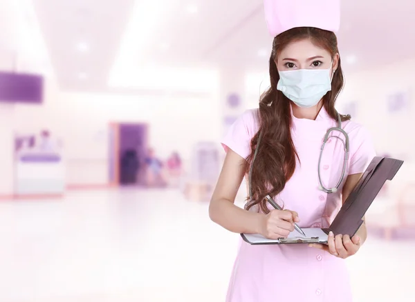 Женщина-медсестра пишет медицинское заключение в больнице — стоковое фото