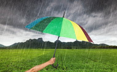 Khao Jee, düşen yağmur ile çok renkli şemsiye tutan el