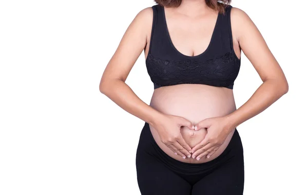 Mulher grávida segurando as mãos em forma de coração em sua barriga i — Fotografia de Stock