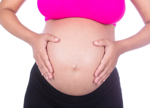 Primer plano del vientre de la mujer embarazada con su mano en ella en ba blanca —  Fotos de Stock