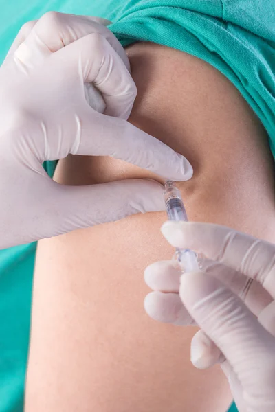 Sjuksköterska med spruta som ger vaccin till en patient — Stockfoto