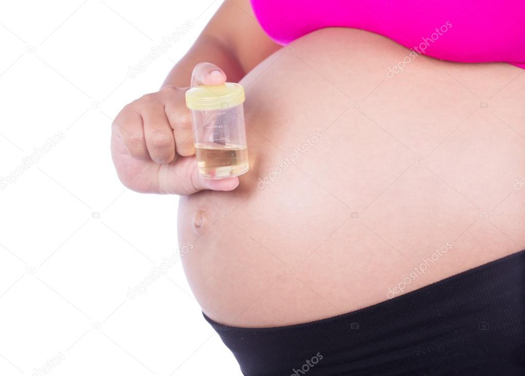 close-up belly of pregnant woman with urine bottle on white back