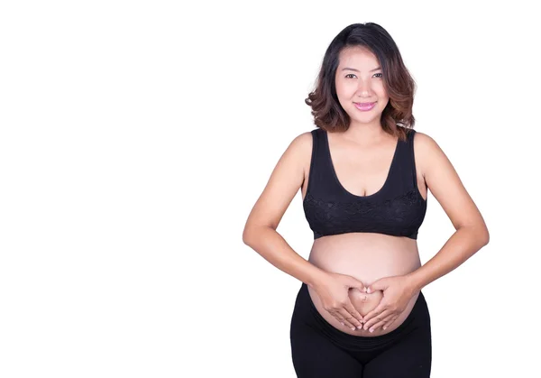 Mulher grávida segurando as mãos em forma de coração em sua barriga i — Fotografia de Stock