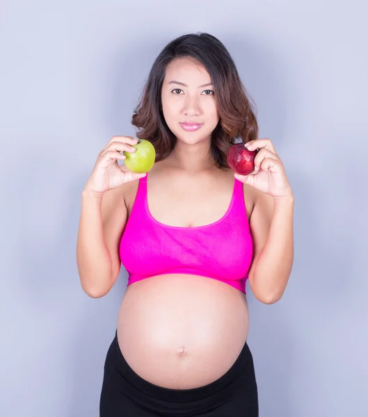 Elma gri arka plan üzerinde güzel hamile kadınla — Stok fotoğraf