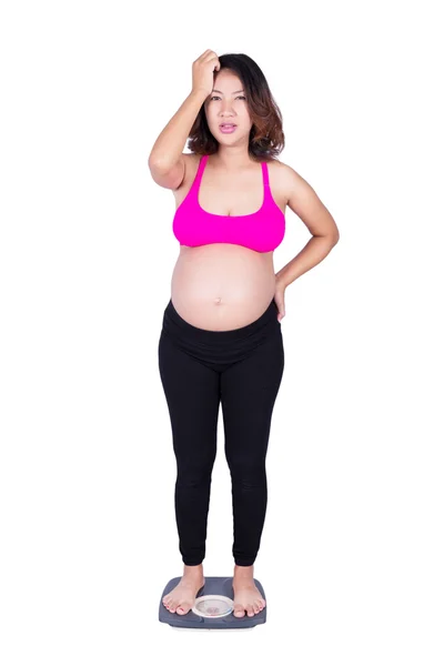 Mujer embarazada preocupada en escala aislada en blanco —  Fotos de Stock