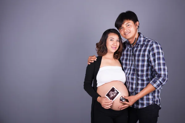 Felice incinta e marito con stetoscopio e immagine ad ultrasuoni — Foto Stock