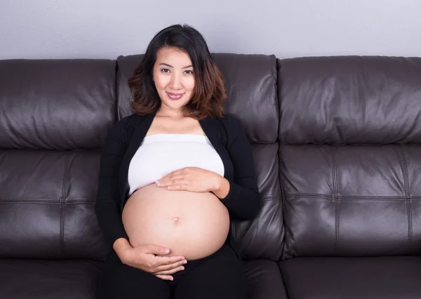 Femme enceinte se reposant à la maison sur le canapé — Photo