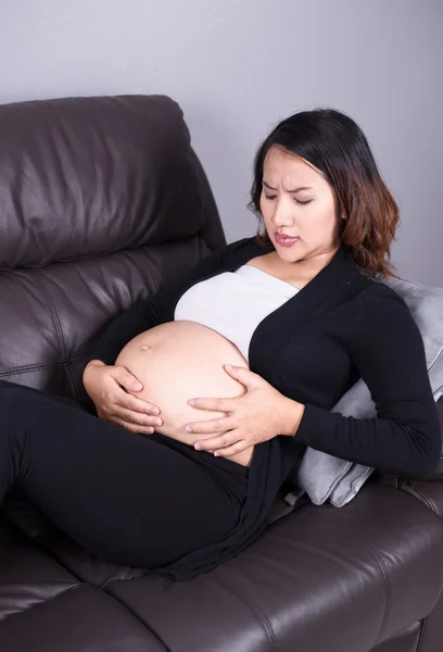 Mulher grávida recebendo uma contração na sala de estar — Fotografia de Stock