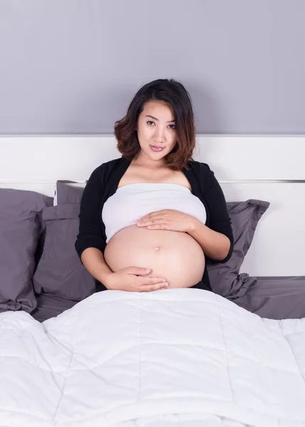Mulher grávida deitada na cama no quarto — Fotografia de Stock