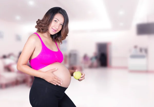 Mujer embarazada hermosa con manzana verde en el hospital — Foto de Stock