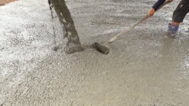 Kaldırımın yükseltilmesi sırasında çimento dökülüyor
